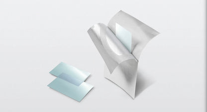 Two translucent light blue square sheets with a metallic silver backing, shown on a clean light gray background. One sheet is standing upright with its backing peeled back, revealing a smooth light blue interior, while the other lies flat beside it.