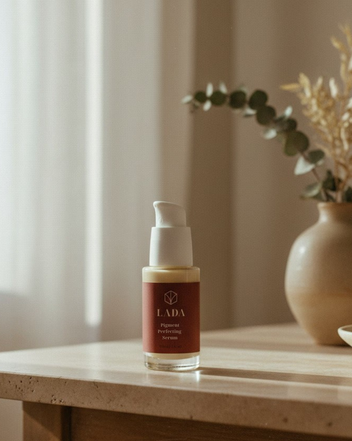 LADA Pigment Perfecting Serum bottle on a wooden table with a vase and plant in the background, skincare for dark spots in Las Cruces, NM
