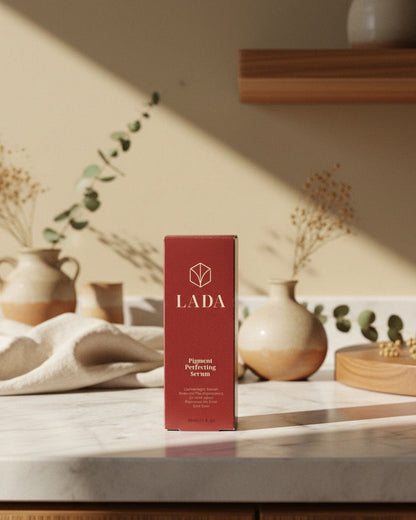 LADA Pigment Perfecting Serum box on a marble surface with decorative items, hyperpigmentation serum from LADA Beauty serving El Paso, TX